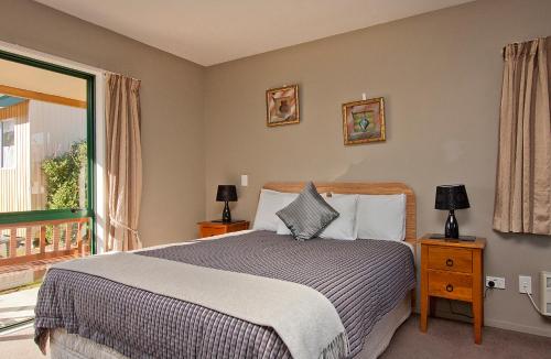 阿什伯顿考尔馁申公园汽车旅馆的一间卧室设有一张床和一个大窗户