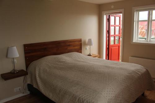 Kolkuós Kolkuós Guesthouse的一间卧室设有一张床和一扇红色的门