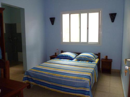 迭戈苏瓦雷斯Residence Kathyly的蓝色客房的一张床位,设有窗户