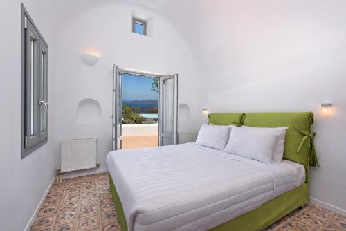 梅加洛克里阿南达度假别墅的一张白色的床,在房间里设有绿色床头板