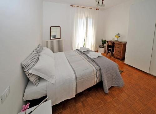 贝拉吉奥Vitali Apartments Bellagio的一间卧室设有一张大床,铺有木地板
