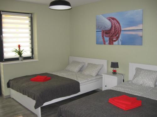 米科瓦伊基Mleczarnia z prywatnym jacuzzi的一间卧室配有两张带红色毛巾的床。