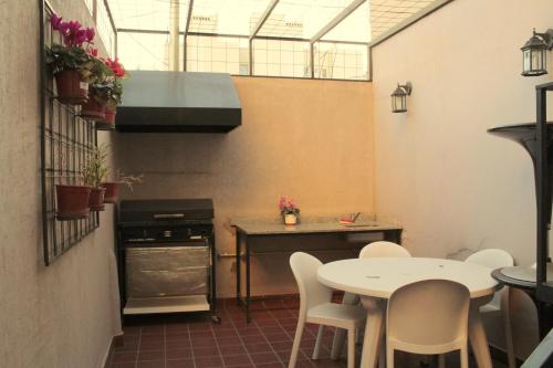 布宜诺斯艾利斯Hagoth Hostel的厨房配有桌椅和炉灶。