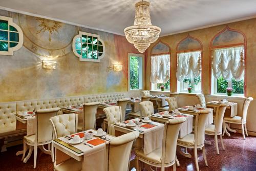 威尼斯伽丁纳酒店的一间带桌椅和吊灯的餐厅