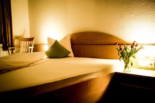 辛斯海姆库弗尔辛克酒店的一间卧室,配有一张带花瓶的床