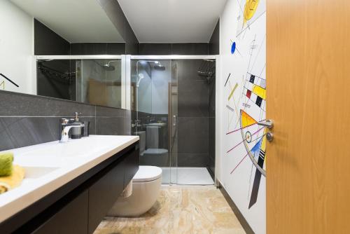 大加那利岛拉斯帕尔马斯Suites Garden Loft Kandinsky的浴室配有卫生间、盥洗盆和淋浴。