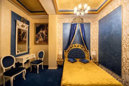 康斯坦察Belle Epoque Boutique (Adult Only)的一间卧室配有一张带桌椅的金色床