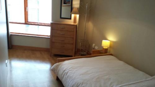 都柏林福利街公寓的一间卧室配有一张床、一个梳妆台和一扇窗户。