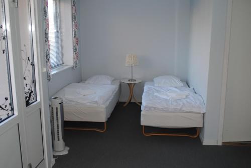 伦讷德特里列酒店的客房设有两张床和一张带台灯的桌子。