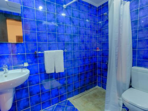 马特鲁港Porto Matrouh Apartments By Amer-Group的蓝色瓷砖浴室设有卫生间和水槽