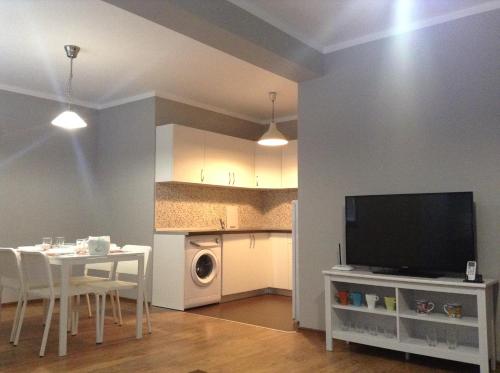 索非亚Apartment Sredetz的一间带桌子和电视的客厅以及一间厨房。