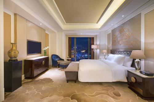 沈阳沈阳富力万达文华酒店的卧室设有一张白色大床和大窗户