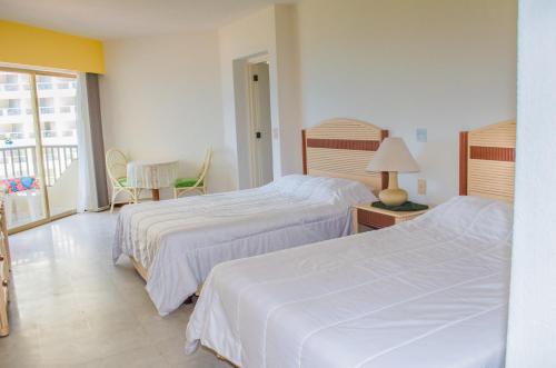 伊斯塔帕ENNA INN IXTAPA DEPARTAMENTO 01 RECAMARA ViSTA MAR的酒店客房设有两张床和一个阳台。