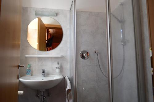 Magrè allʼ AdigeHotel Zur Kirche的浴室配有盥洗盆和带镜子的淋浴
