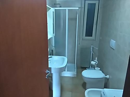 吉诺萨滨海Apartment C的浴室配有白色水槽和卫生间。