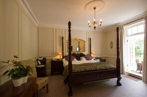 罗泽尔哈顿主教城堡酒店的一间卧室配有一张天蓬床和吊灯。