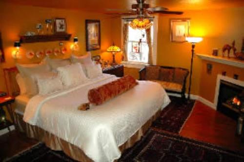 北康威红色大象住宿加早餐旅馆的一间卧室设有一张大床和一个壁炉