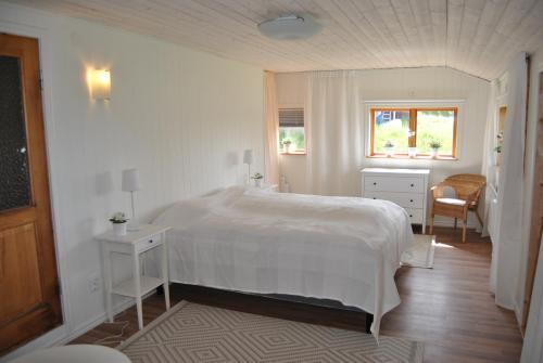 奥萨Orsastuguthyrning-Höglunda的白色的卧室设有一张大床和一个窗户