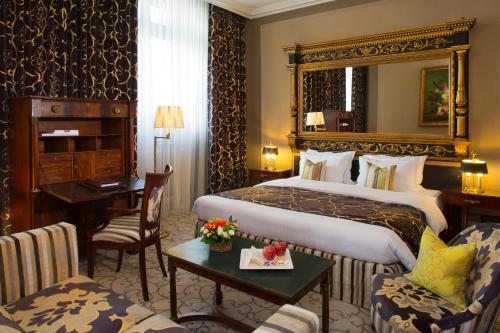 日内瓦白鹤酒店的酒店客房设有一张大床和一张书桌。