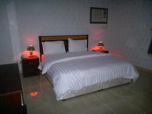 延布شقق ضيافة خاصة的一间卧室配有一张带两盏灯的大型白色床。