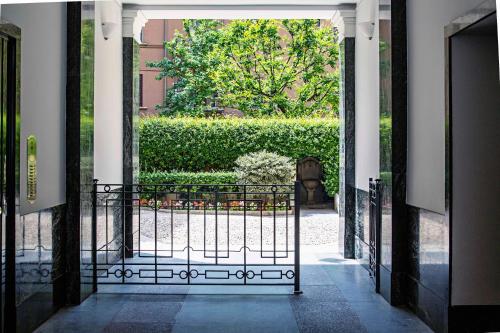 米兰索尔费里诺套房公寓的通往带树 ⁇ 的花园的开放式门