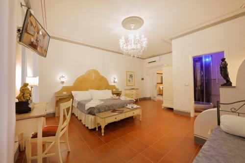 蒙特瓦尔基Palazzo Mari suite & rooms b&b的卧室配有一张床和一张桌子