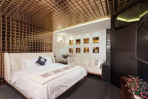 首尔空达设计师酒店的卧室配有一张白色的大床和一张沙发。