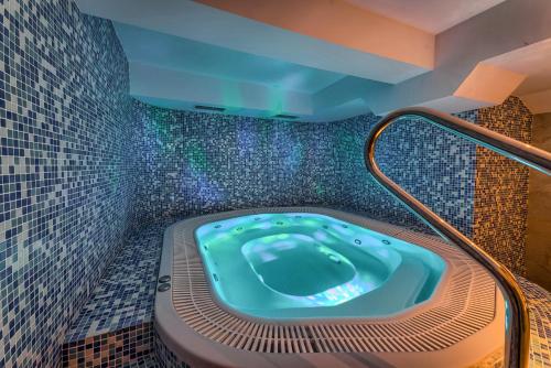 克鲁斯兹考采Hotel Pod Wulkanem的浴室设有按摩浴缸,铺有马赛克瓷砖。