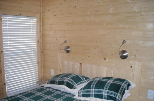 Harden Flat优胜美地湖区49号小屋度假酒店的卧室配有木墙内的一张床