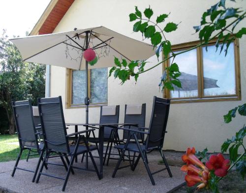 凯希道库什塔尼维奥拉温德加公寓的桌椅和白色遮阳伞