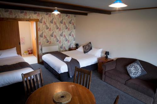 格林坦纳格林坦纳公园中心的酒店客房设有两张床、一张沙发和一张桌子。