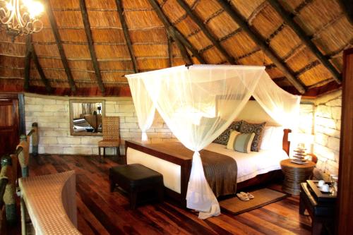 MkalinzuSerena Mivumo River Lodge的一间卧室配有一张带天蓬的床