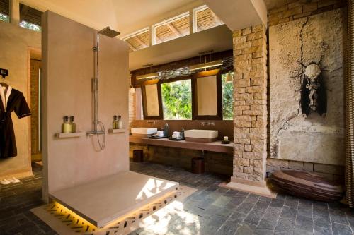 PannaPashan Garh Panna National Park - A Taj Safari Lodge的带淋浴和盥洗盆的大浴室