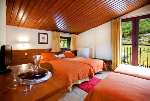 阿林萨尔蒙塔纳酒店的一间卧室设有两张床、一台电视和一扇窗户。