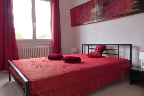 卢瓦尔河畔米德Gîte Au fil de l'eau的一间卧室配有红色的床和红色枕头