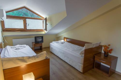 奇夫利克Hera Guest House的一间卧室设有两张床、一台电视和一扇窗户。
