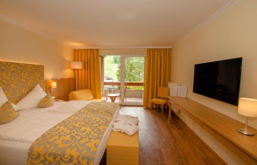 巴德小基希海姆Evident Hotel Prägant的配有一张床和一台平面电视的酒店客房