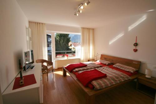 奥伯斯特多夫Ferienwohnung Vormann的一间卧室配有一张床、一张书桌和一个窗户。