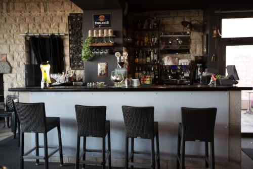 Saint-Aignan-de-Cramesnil拉杰勒斯酒店的吧台上设有四把椅子的酒吧