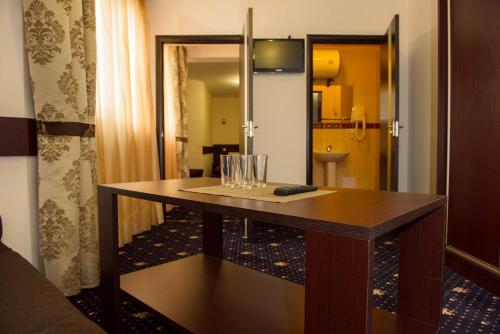 伊万诺-弗兰科夫斯克Faraon Hotel的一张木桌,位于带镜子的房间里