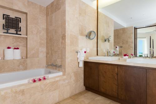格雷斯湾贝斯特海湾俱乐部度假村的浴室设有2个水槽、浴缸和镜子
