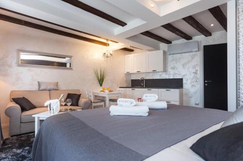 罗维尼皇家公寓的一间卧室设有一张床和一间客厅。