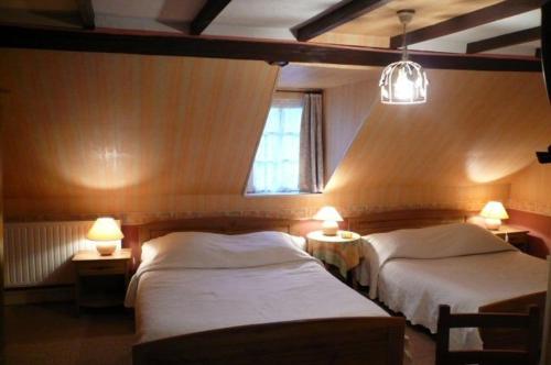 索姆河畔圣瓦莱里亨利四世酒店 的一间卧室设有两张床、两盏灯和一个窗户。