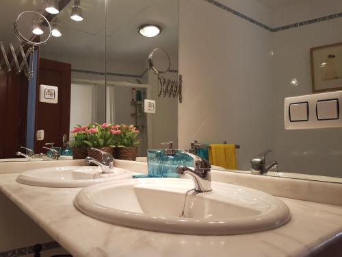 塞维利亚阿提科圣克莱门特公寓的一间带两个盥洗盆和大镜子的浴室