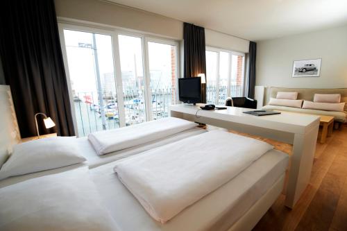 不来梅港不来梅哈芬因杰赫酒店公寓式酒店的酒店客房配有两张床和一张书桌