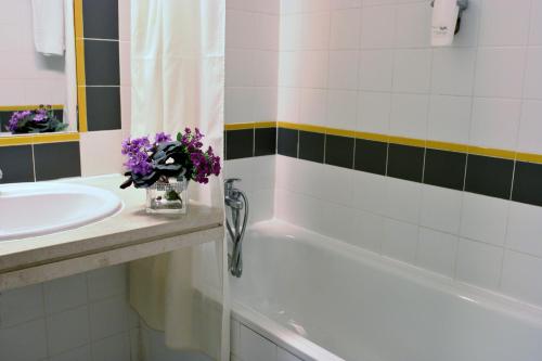 布拉加Flag Hotel Braga的浴室设有水槽和花卉浴缸。