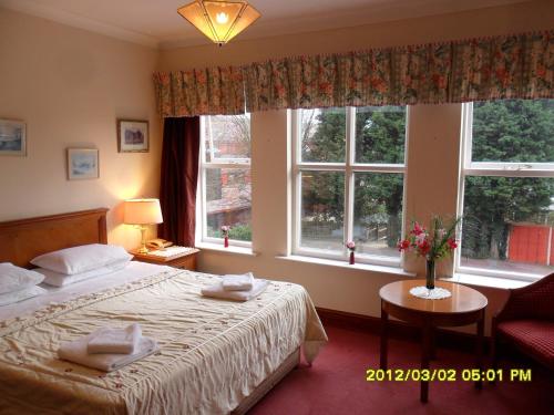 彼得伯勒索普洛奇酒店的一间卧室设有一张床和两个窗户。