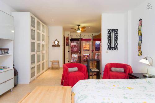 拉拉古纳Apartamento La Higuera的一间卧室配有两张红色椅子和一张床