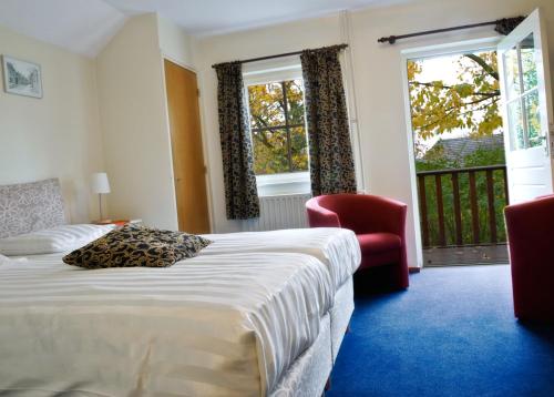 梅赫伦Hotel De Oude Brouwerij的酒店客房带一张床、椅子和窗户