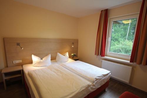 特拉森海德特拉森穆尔度假公寓的一间卧室配有一张带白色床单的床和一扇窗户。